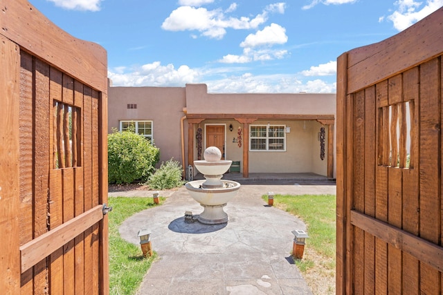 704 Tyler Rd NW, Los Ranchos, NM 87107 - doorway to property with stucco siding and a patio area