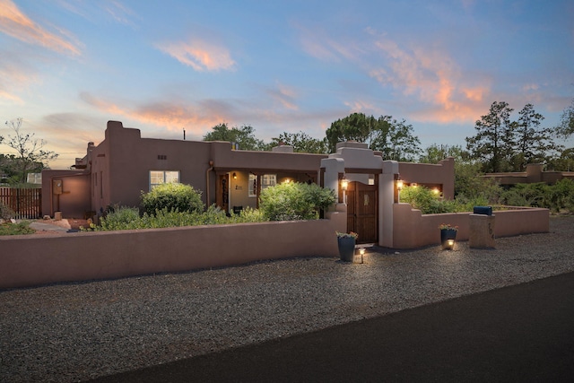 704 Tyler Rd NW, Los Ranchos, NM 87107 - pueblo revival-style home with stucco siding and a gate