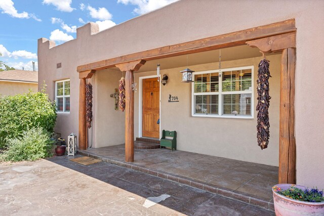 704 Tyler Rd NW, Los Ranchos, NM 87107 - view of exterior entry featuring stucco siding and covered porch