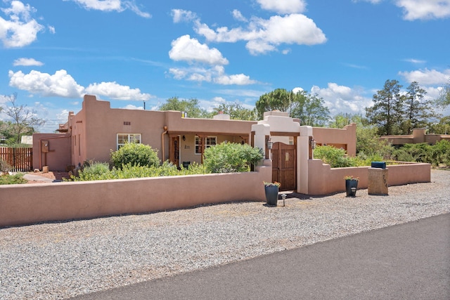 704 Tyler Rd NW, Los Ranchos, NM 87107 - pueblo-style home featuring stucco siding and a gate