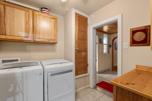 704 Tyler Rd NW, Los Ranchos, NM 87107 - laundry room with cabinet space, light tile patterned floors, washing machine and dryer, and a textured ceiling