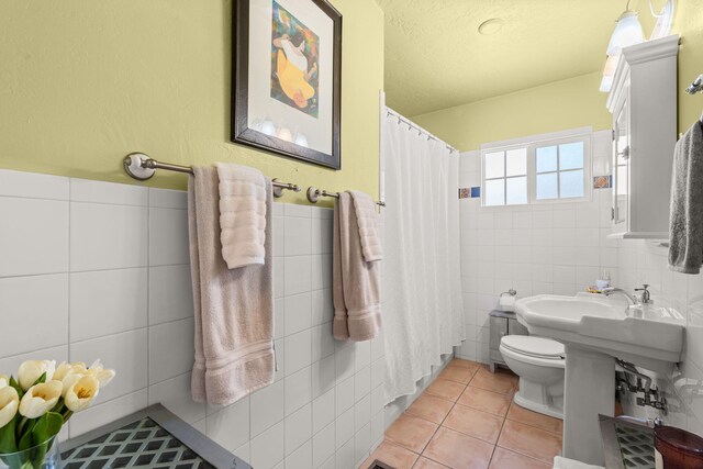 704 Tyler Rd NW, Los Ranchos, NM 87107 - bathroom with tile walls, tile patterned floors, curtained shower, a textured ceiling, and a wainscoted wall