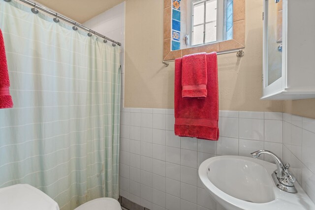 704 Tyler Rd NW, Los Ranchos, NM 87107 - full bathroom featuring tile walls, curtained shower, and wainscoting