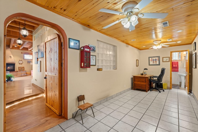 704 Tyler Rd NW, Los Ranchos, NM 87107 - office area featuring wooden ceiling, ceiling fan, arched walkways, light tile patterned floors, and ornamental molding