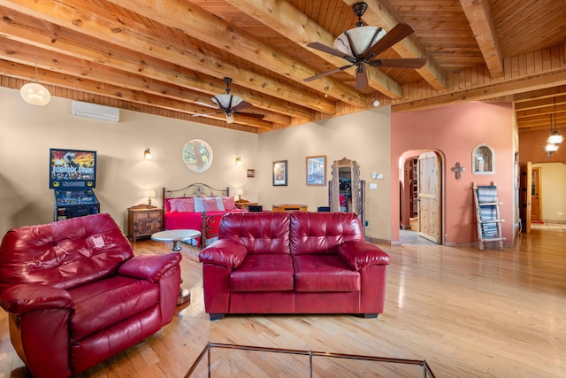 704 Tyler Rd NW, Los Ranchos, NM 87107 - cinema room featuring a ceiling fan, a wall unit AC, a wood ceiling with exposed beams, wood finished floors, and arched walkways
