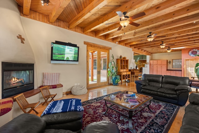 704 Tyler Rd NW, Los Ranchos, NM 87107 - living area featuring a ceiling fan, a large fireplace, healthy amount of natural light, wood finished floors, and a wood ceiling with exposed beams