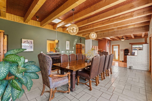 704 Tyler Rd NW, Los Ranchos, NM 87107 - dining space with beam ceiling, a chandelier, arched walkways, and stone tile floors