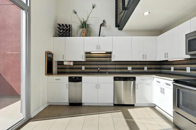 524 Central Ave SW # 803, Albuquerque, NM 87102 - kitchen featuring appliances with stainless steel finishes, decorative backsplash, light tile patterned floors, white cabinets, and recessed lighting