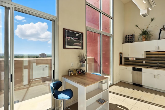524 Central Ave SW # 803, Albuquerque, NM 87102 - kitchen featuring healthy amount of natural light, light tile patterned floors, white cabinetry, and a towering ceiling