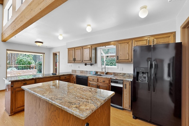 1865 Tramway Terrace Loop NE, Albuquerque, NM 87122 - kitchen featuring black appliances, a peninsula, brown cabinetry, light wood-style flooring, and plenty of natural light