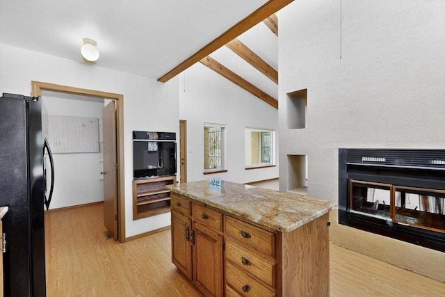 1865 Tramway Terrace Loop NE, Albuquerque, NM 87122 - kitchen with freestanding refrigerator, light wood-style floors, brown cabinetry, and light stone counters