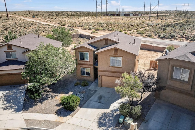 1324 Desert Paintbrush Loop, Rio Rancho, NM 87144 - view of front facade with a desert view, an attached garage, driveway, and stucco siding