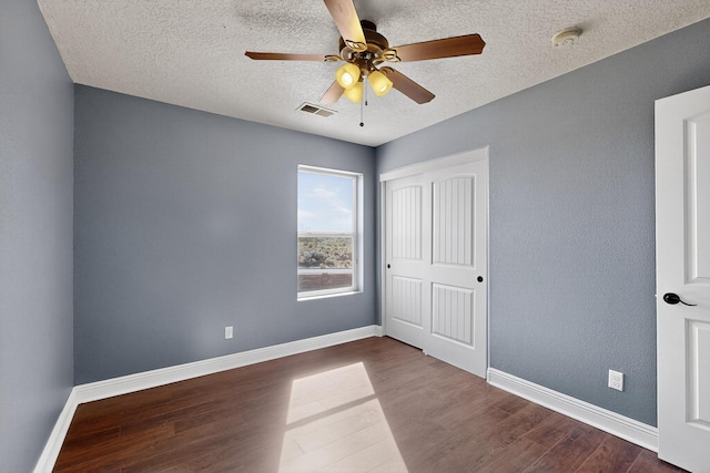 1324 Desert Paintbrush Loop, Rio Rancho, NM 87144 - unfurnished bedroom featuring dark wood-style floors, a textured ceiling, a closet, and a ceiling fan