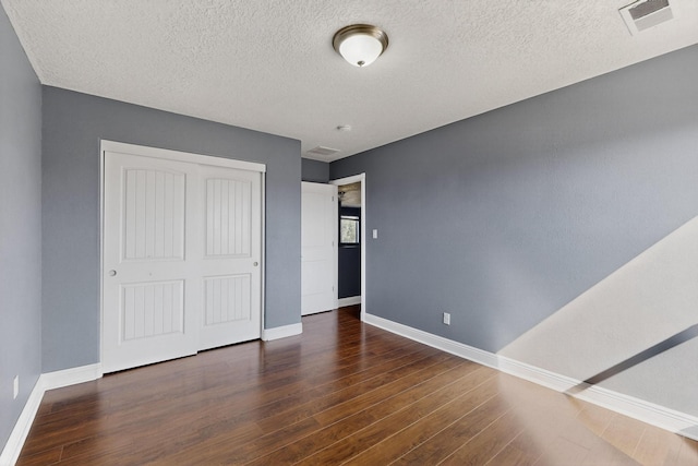 1324 Desert Paintbrush Loop, Rio Rancho, NM 87144 - unfurnished bedroom featuring wood finished floors, a closet, and a textured ceiling