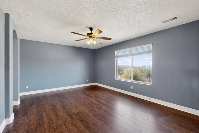 1324 Desert Paintbrush Loop, Rio Rancho, NM 87144 - spare room with a ceiling fan, dark wood-type flooring, arched walkways, and a textured ceiling