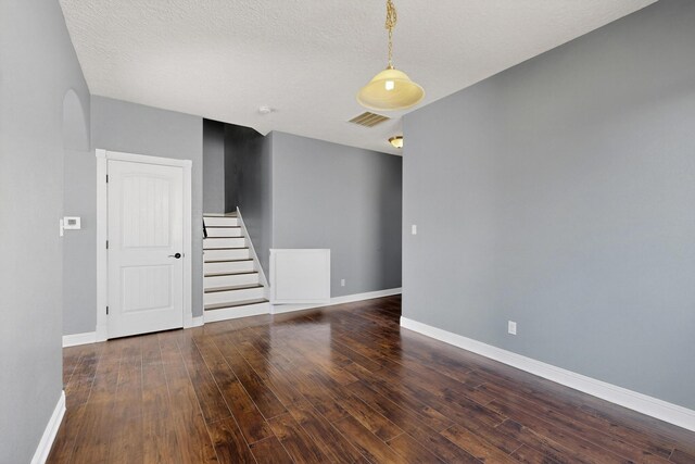 1324 Desert Paintbrush Loop, Rio Rancho, NM 87144 - unfurnished room with stairway, hardwood / wood-style floors, arched walkways, and a textured ceiling