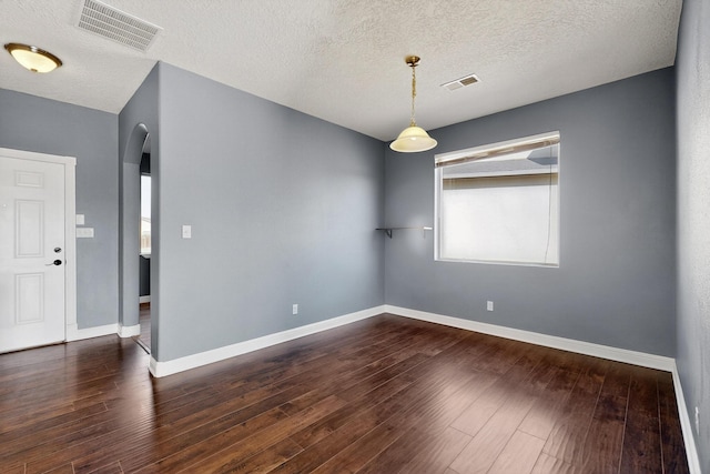 1324 Desert Paintbrush Loop, Rio Rancho, NM 87144 - empty room with arched walkways, dark wood finished floors, and a textured ceiling