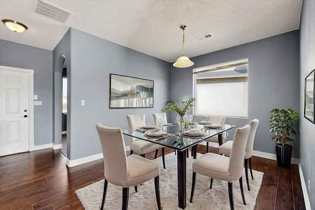 1324 Desert Paintbrush Loop, Rio Rancho, NM 87144 - dining space featuring hardwood / wood-style floors, arched walkways, and a textured ceiling
