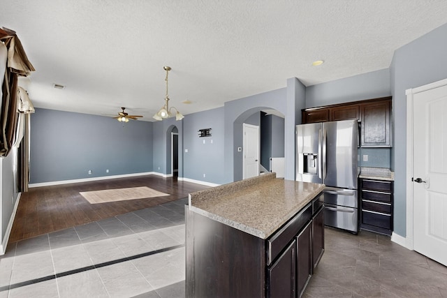 1324 Desert Paintbrush Loop, Rio Rancho, NM 87144 - kitchen with arched walkways, stainless steel refrigerator with ice dispenser, ceiling fan, dark brown cabinetry, and a textured ceiling