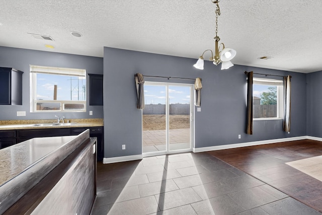 1324 Desert Paintbrush Loop, Rio Rancho, NM 87144 - unfurnished dining area featuring a chandelier and a textured ceiling