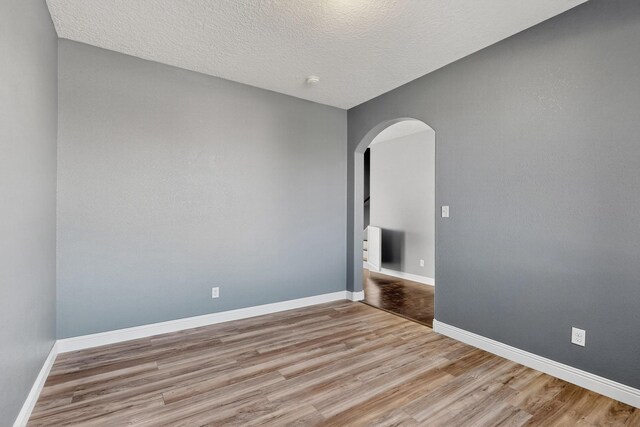1324 Desert Paintbrush Loop, Rio Rancho, NM 87144 - spare room with arched walkways, wood finished floors, and a textured ceiling