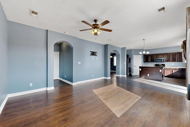 1324 Desert Paintbrush Loop, Rio Rancho, NM 87144 - unfurnished living room with arched walkways, ceiling fan, dark wood finished floors, a textured ceiling, and a chandelier