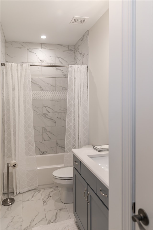 full bathroom featuring toilet, shower / bath combo with shower curtain, and vanity