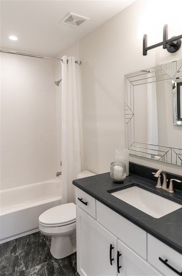 full bathroom featuring toilet, shower / bath combo, and vanity