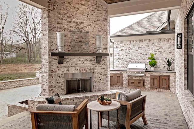 view of patio / terrace with an outdoor brick fireplace, an outdoor kitchen, and a grill