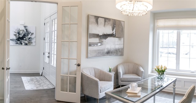 sitting room with french doors, an inviting chandelier, and dark hardwood / wood-style flooring