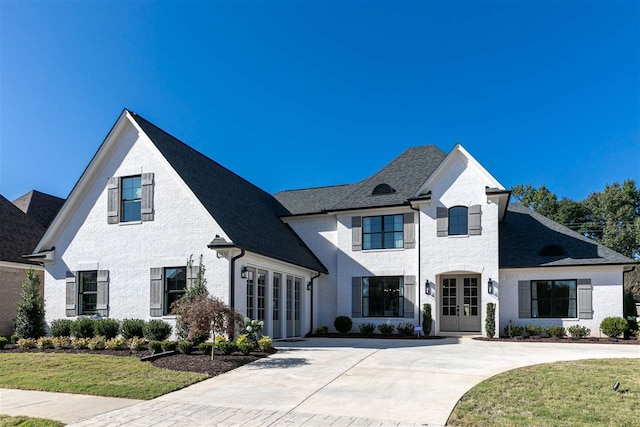 french country home featuring a front lawn and french doors