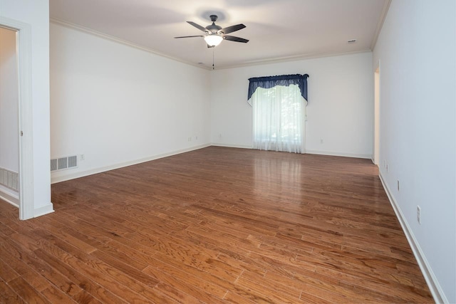 empty room with crown molding, ceiling fan, and dark wood-type flooring