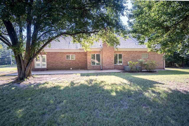 ranch-style home featuring a patio, central air condition unit, and a front yard