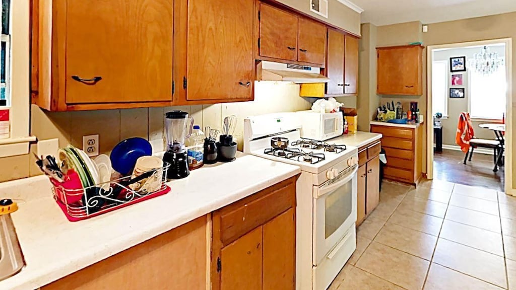 kitchen featuring white appliances and light tile floors