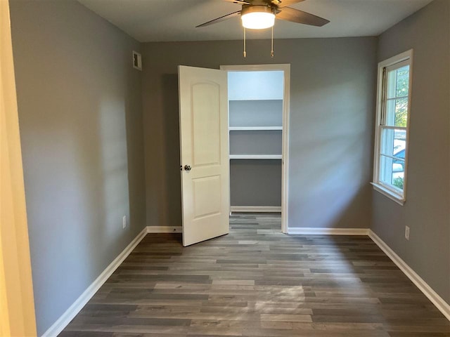 unfurnished bedroom with ceiling fan and dark wood-type flooring