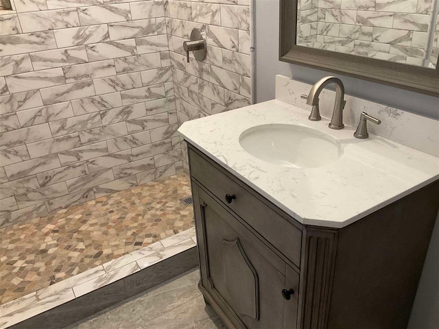 bathroom featuring a tile shower and large vanity