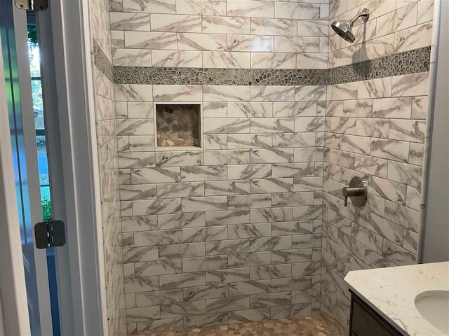 bathroom with vanity and tiled shower