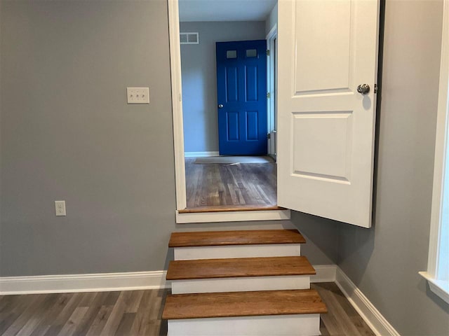 stairs featuring dark wood-type flooring