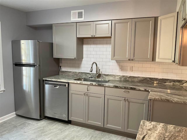 kitchen featuring appliances with stainless steel finishes, sink, backsplash, and gray cabinets