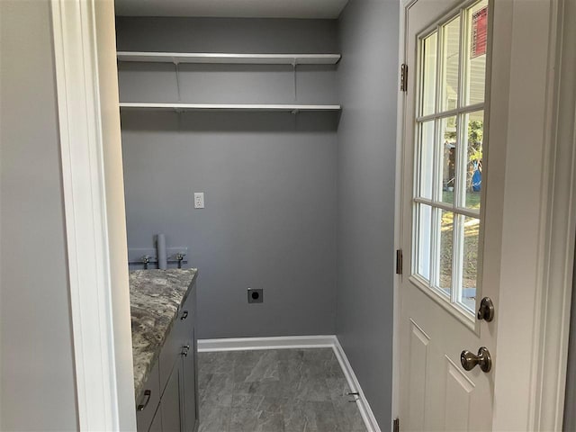 laundry room featuring hookup for an electric dryer and dark tile flooring