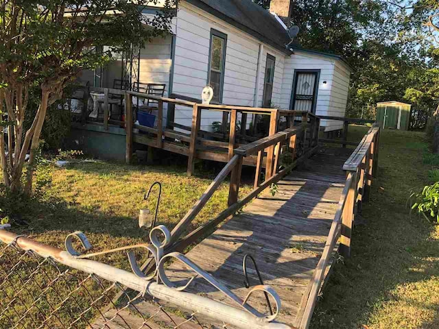 back of house with a yard, a shed, and a wooden deck