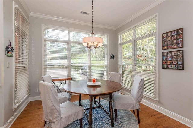 dining area featuring plenty of natural light, crown molding, and light hardwood / wood-style flooring