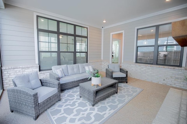 living room featuring brick wall and crown molding