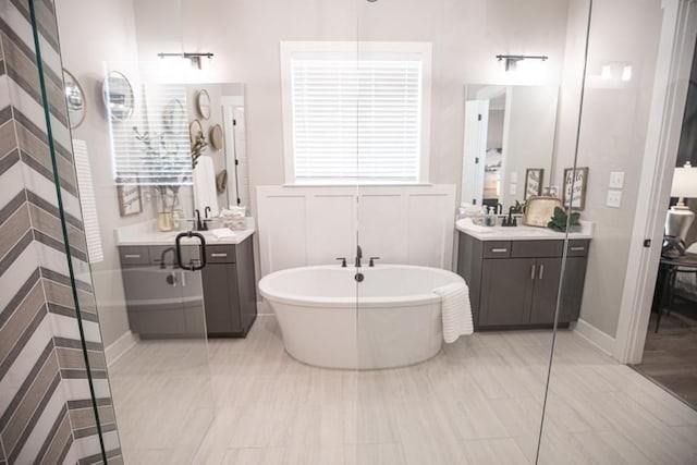 bathroom featuring a tub, tile floors, and double vanity