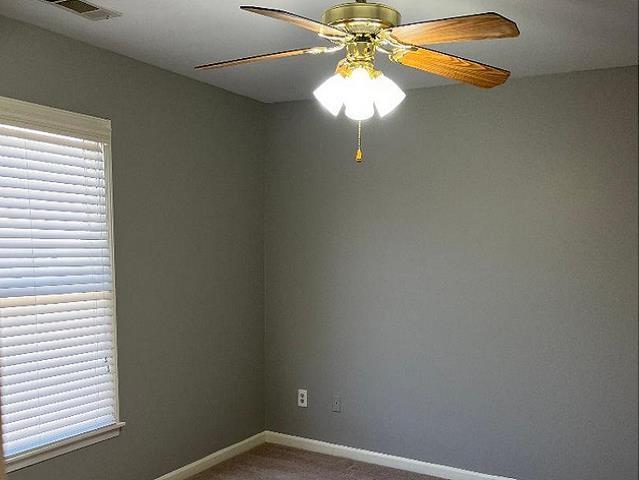 carpeted empty room featuring ceiling fan