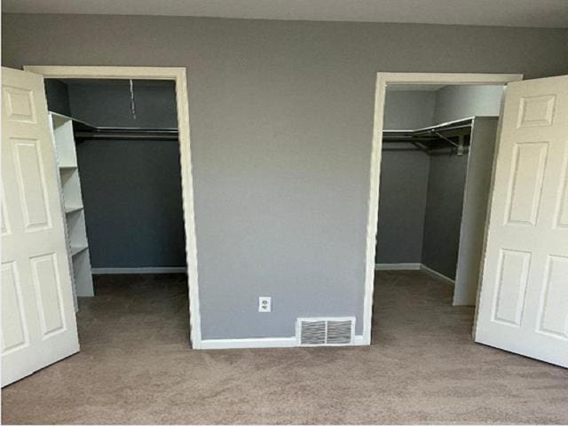 unfurnished bedroom with a closet and light colored carpet