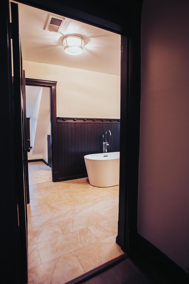 bathroom with a bath and tile flooring