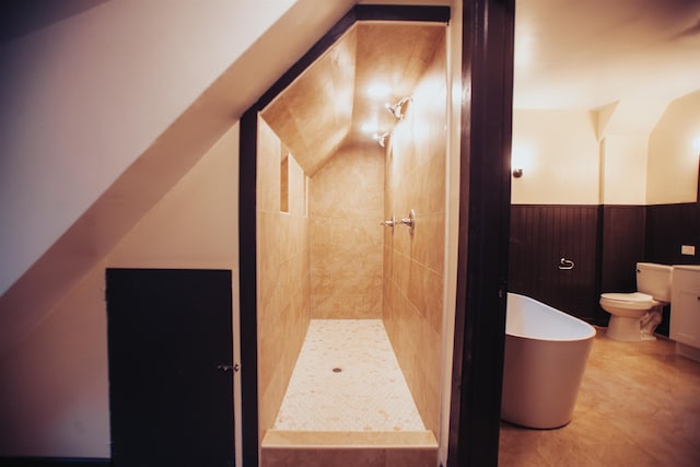 bathroom with vanity, toilet, tiled shower, and tile floors