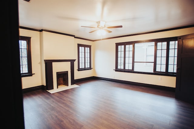 unfurnished living room featuring plenty of natural light, a brick fireplace, dark hardwood / wood-style flooring, and ceiling fan