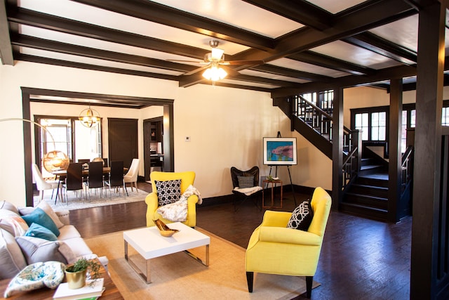 living room with beam ceiling, ceiling fan with notable chandelier, and dark wood-type flooring